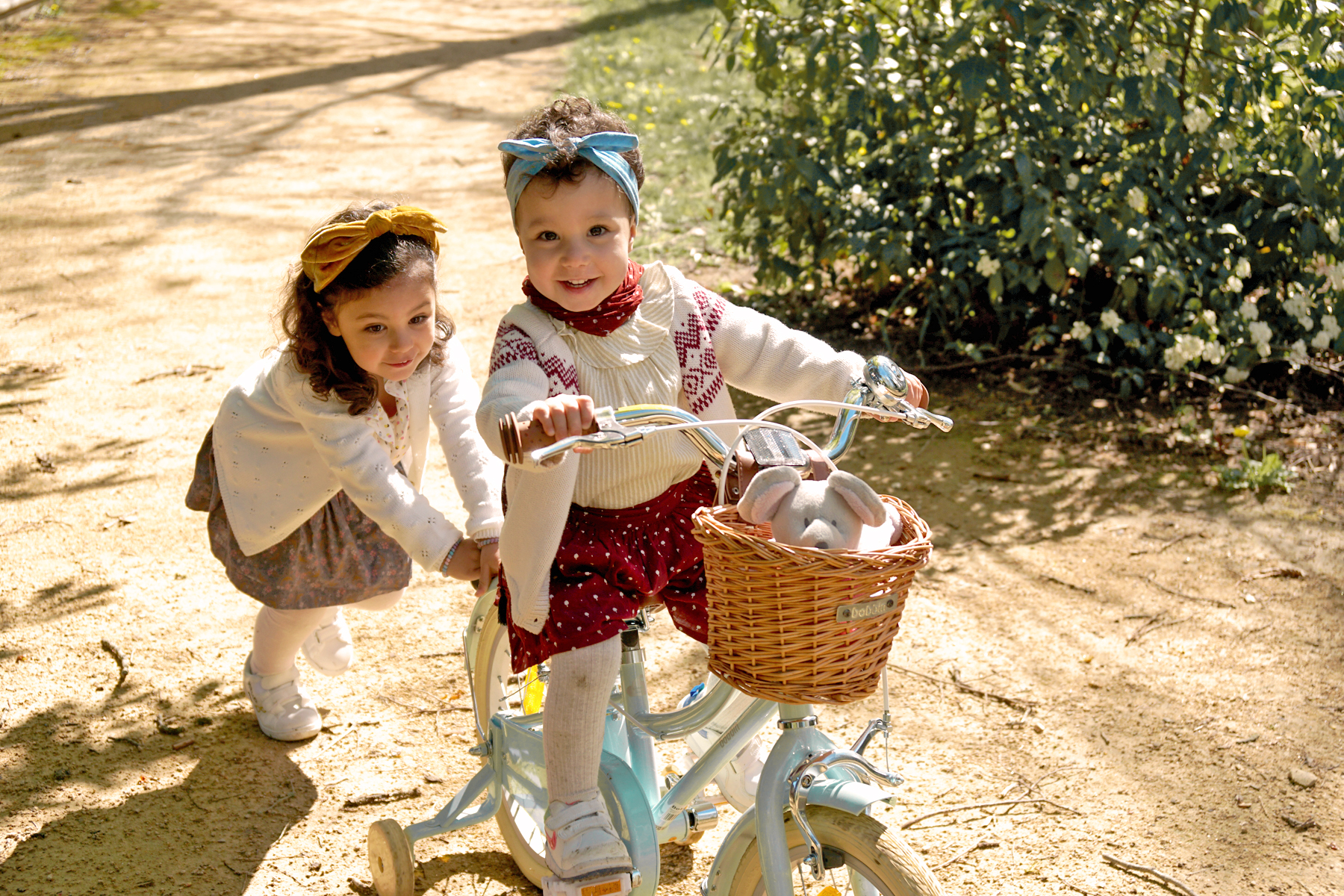Petite fille à vélo poussée par sa soeur