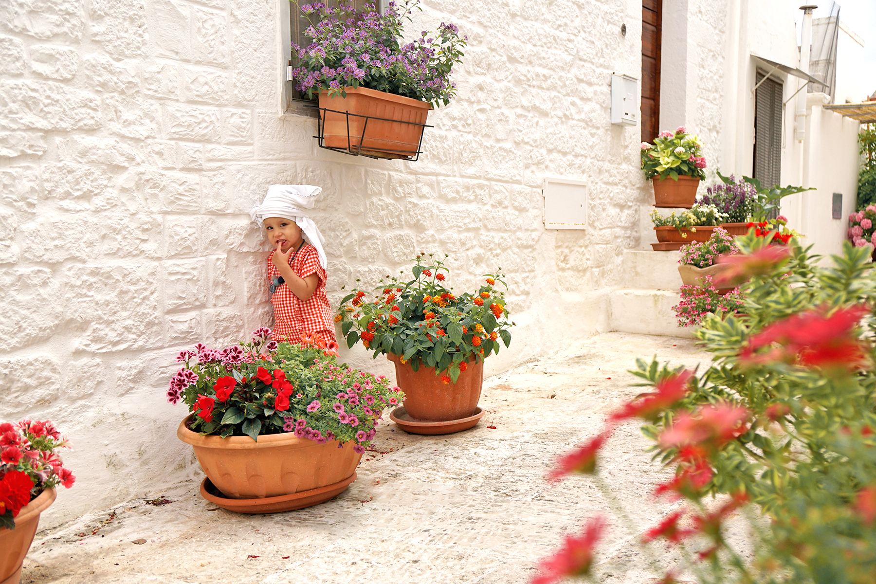 Petite fille et les pots de fleurs à Alberobello, Pouilles Italie