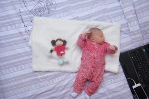 Bébé habillé en Petit Bateau et poupée en tissu Unicef