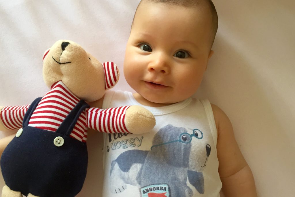 Bébé en body avec son doudou ours