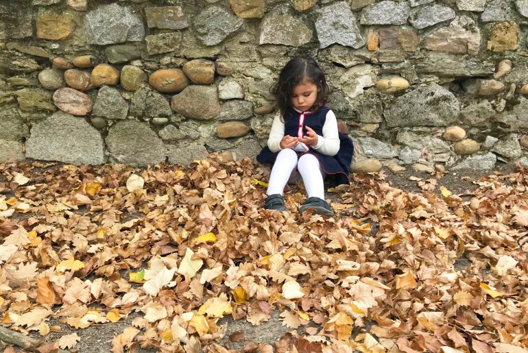 Enfant sur les feuilles au parc de Beauregard en automne
