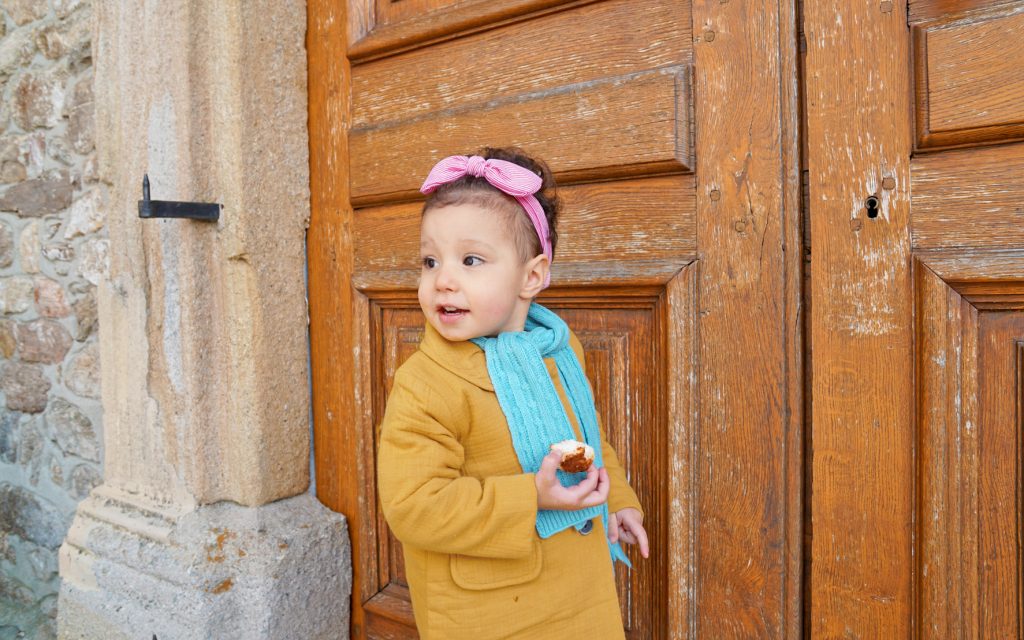 Petite fille joue à 1,2,3 soleil, gâteau en main