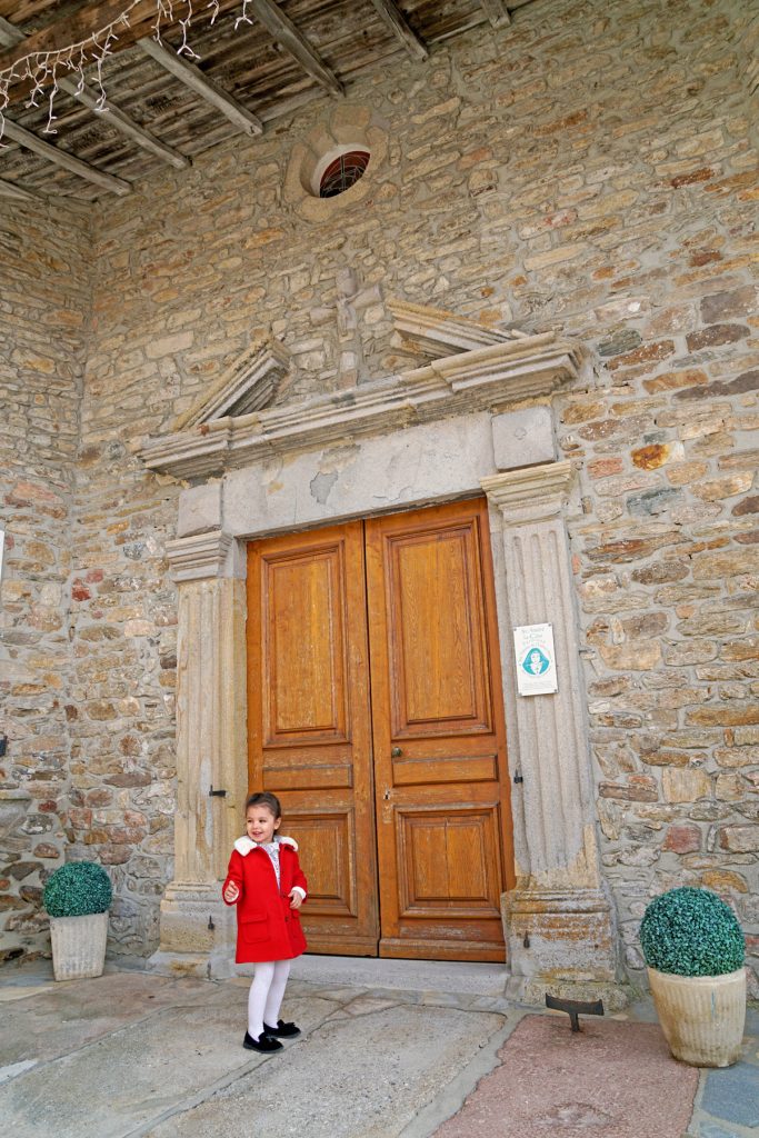 Petite fille joue à 1,2,3 soleil devant une chapelle