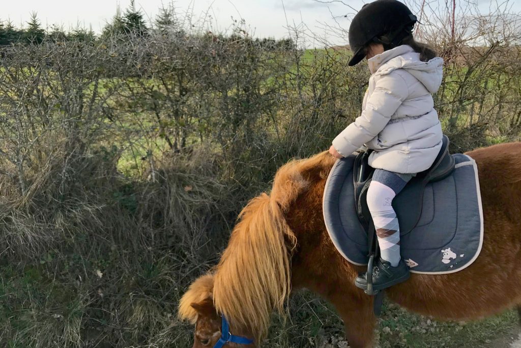 Papa absent, petite fille fait du poney