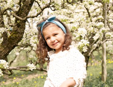Vacances de Pâques - Petite fille au milieu des arbres fruitiers