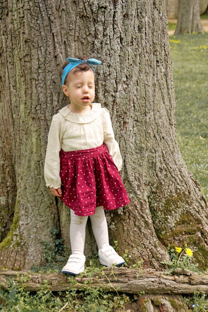 Petite fille devant un arbre