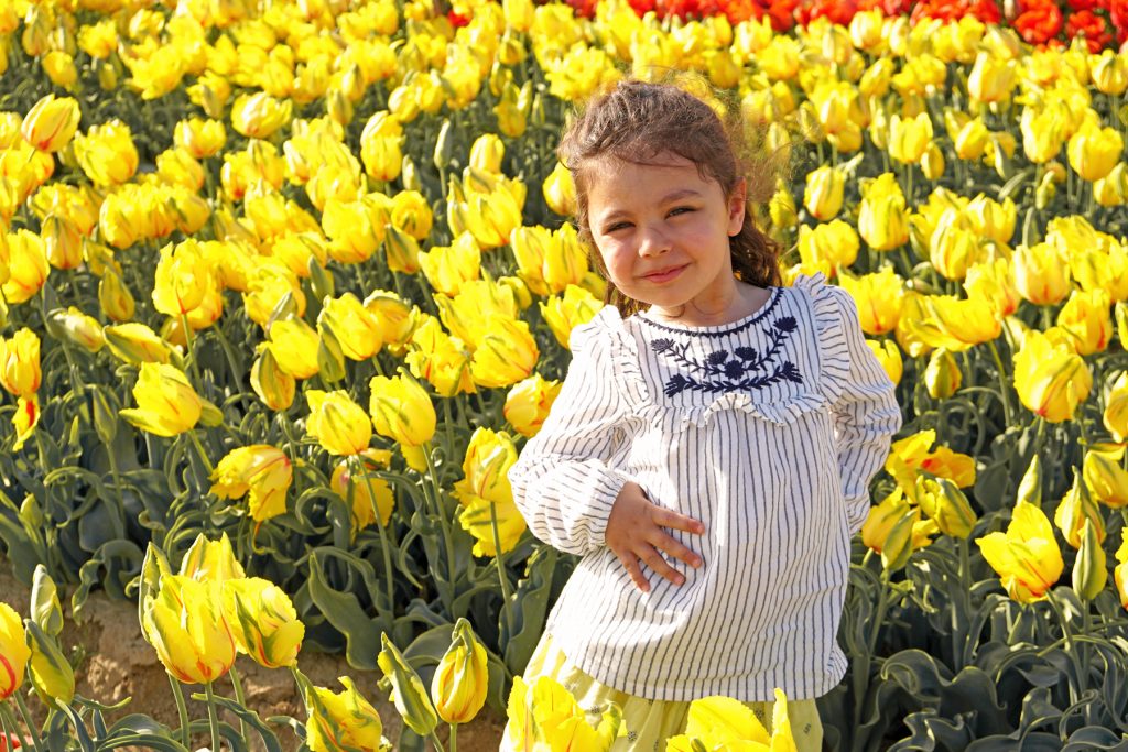 Petite fille dans un champs de tulipes